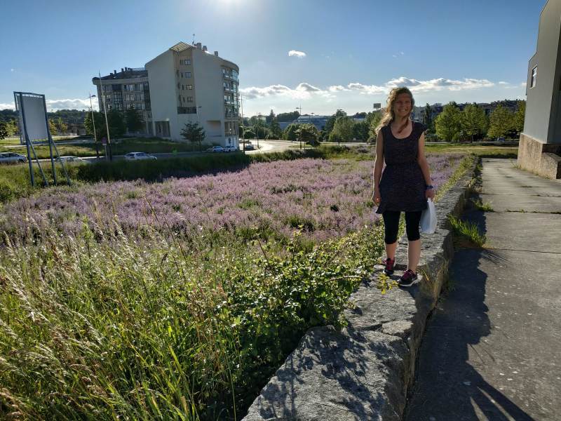 Triumphant stance next to a bright purple field of flowers.